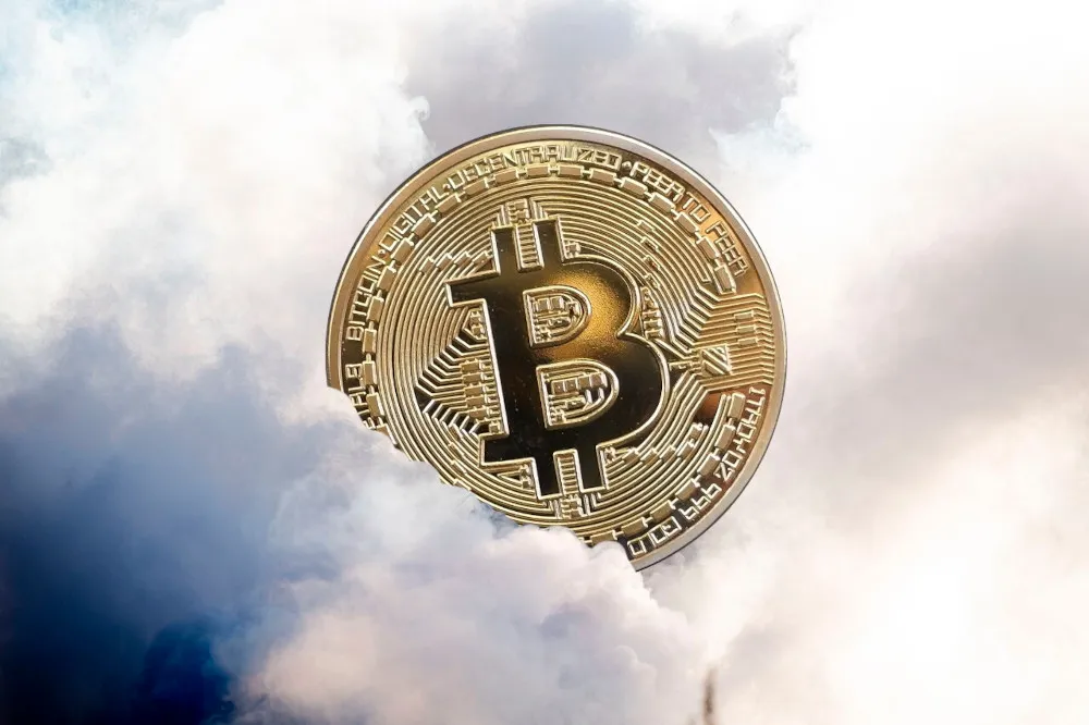 A shiny gold “bitcoin” emerging from a cloud of smoke