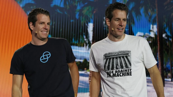 Tyler and Cameron Winklevoss on stage. One of them is wearing a Rage Against the Machine t-shirt.
