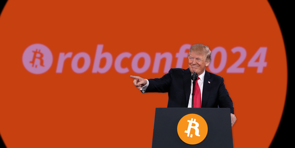 An image of Donald Trump at a podium, pointing, with a logo behind him reading “robconf2024”